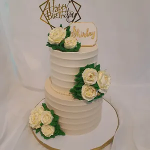 Gâteau d'anniversaire blanc à deux étages avec des roses en crème
