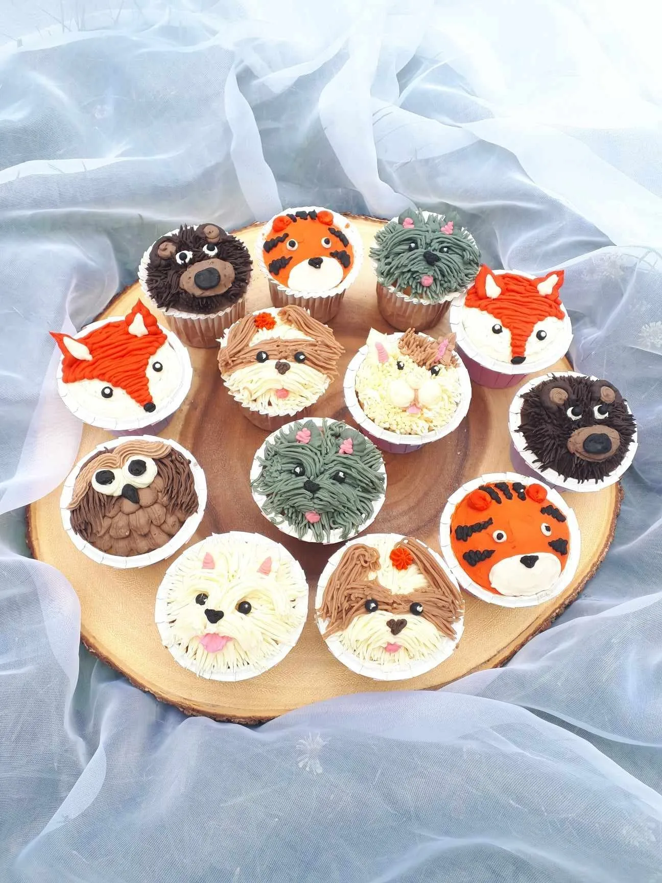 Cupcakes decorated as foxes, tigers, puppies and bears