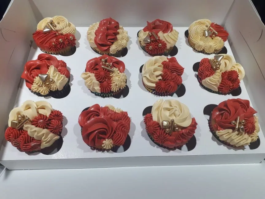 Box of cupcakes with red and cream swirls