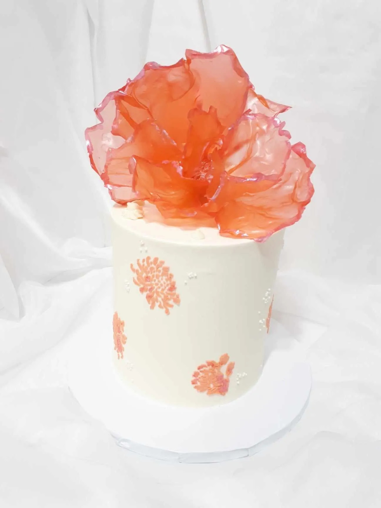 White wedding cake with an orange sugar flower