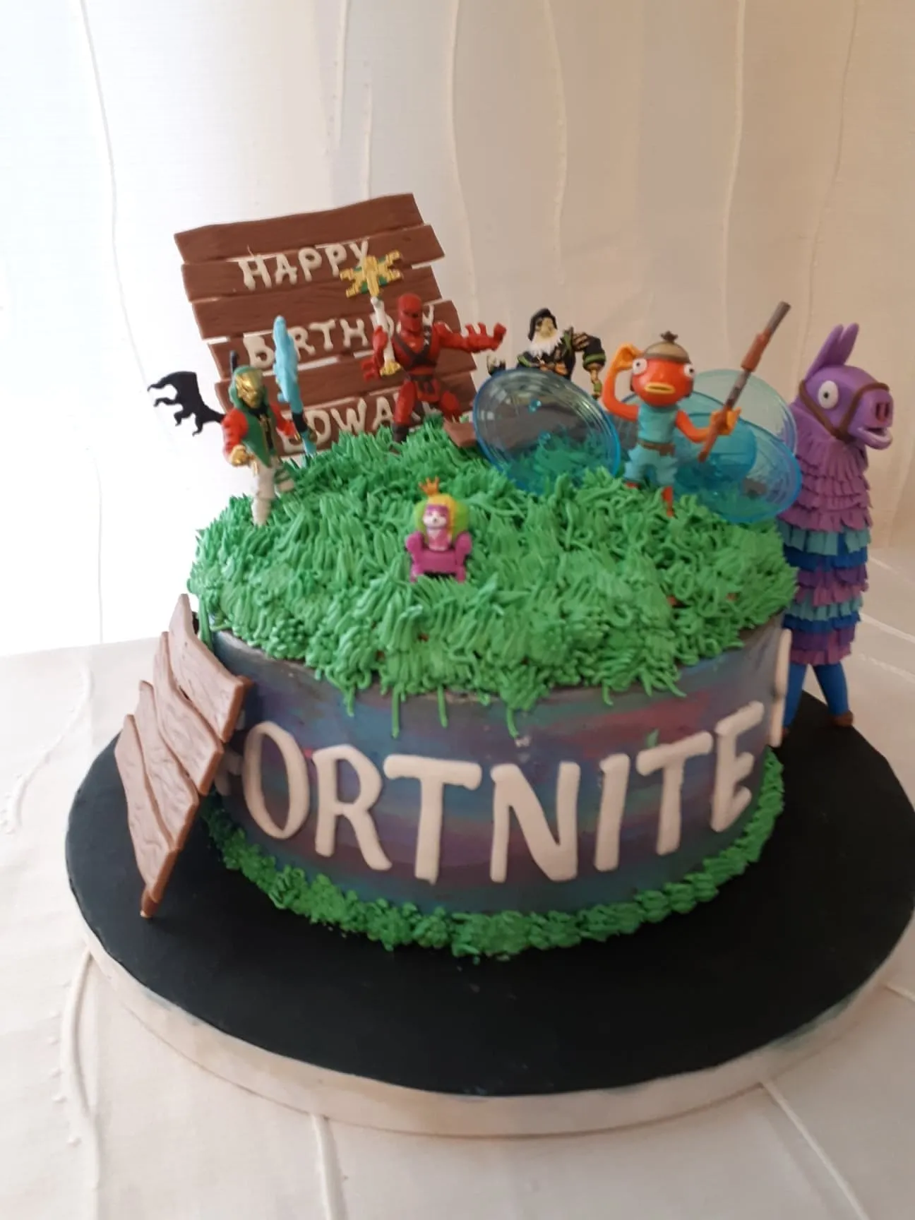 Fortnite birthday cake with a llama and figurines