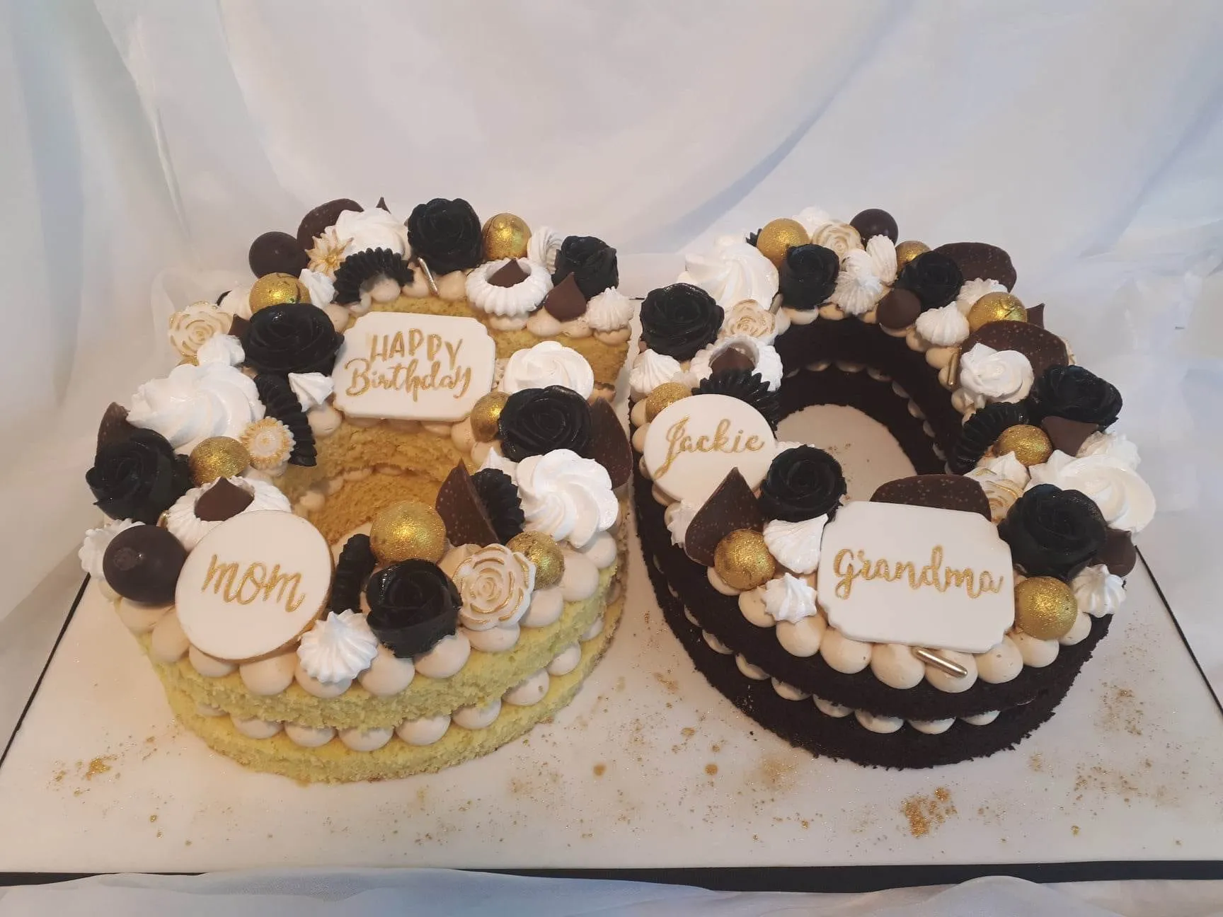 Black, white and gold number 60 cake with birthday plaques