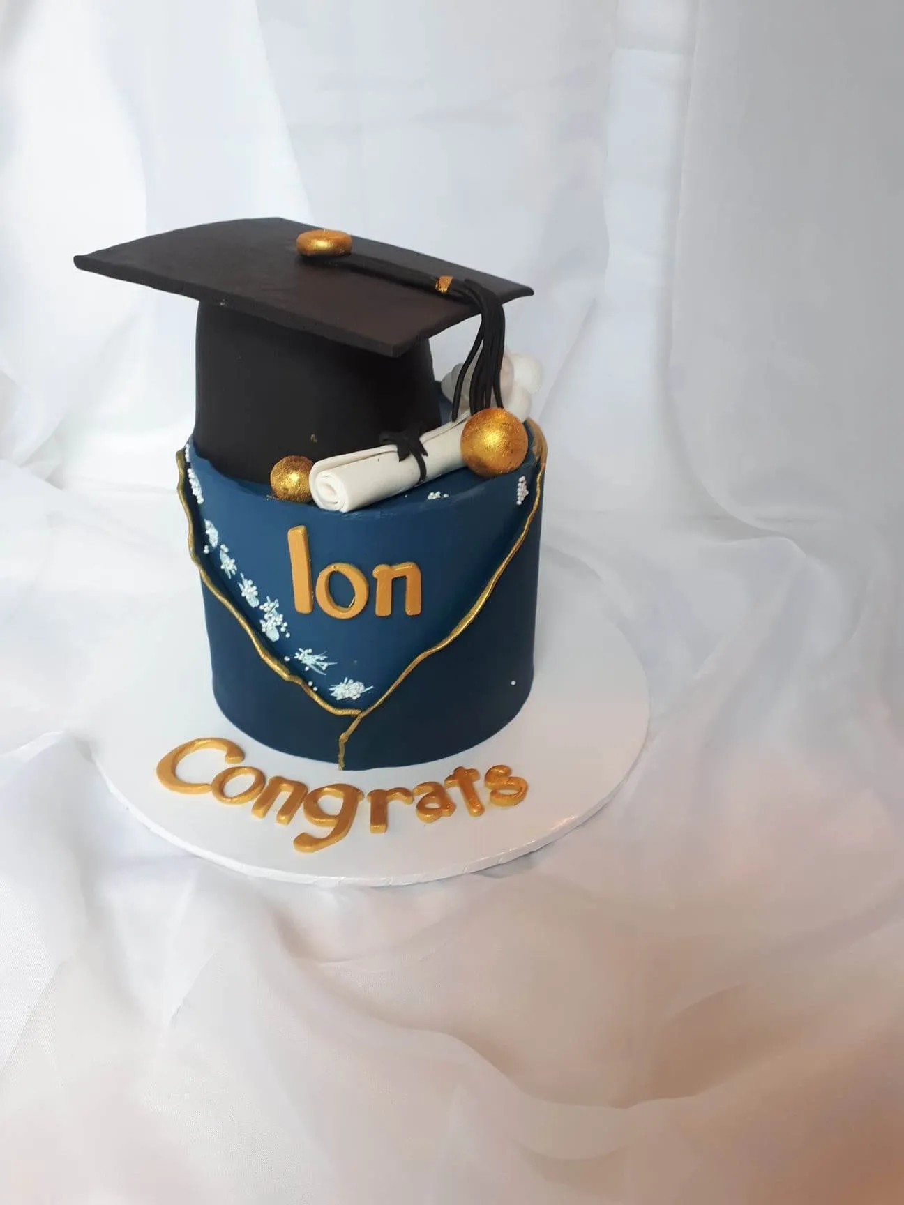 Navy graduation cake with a fondant cap